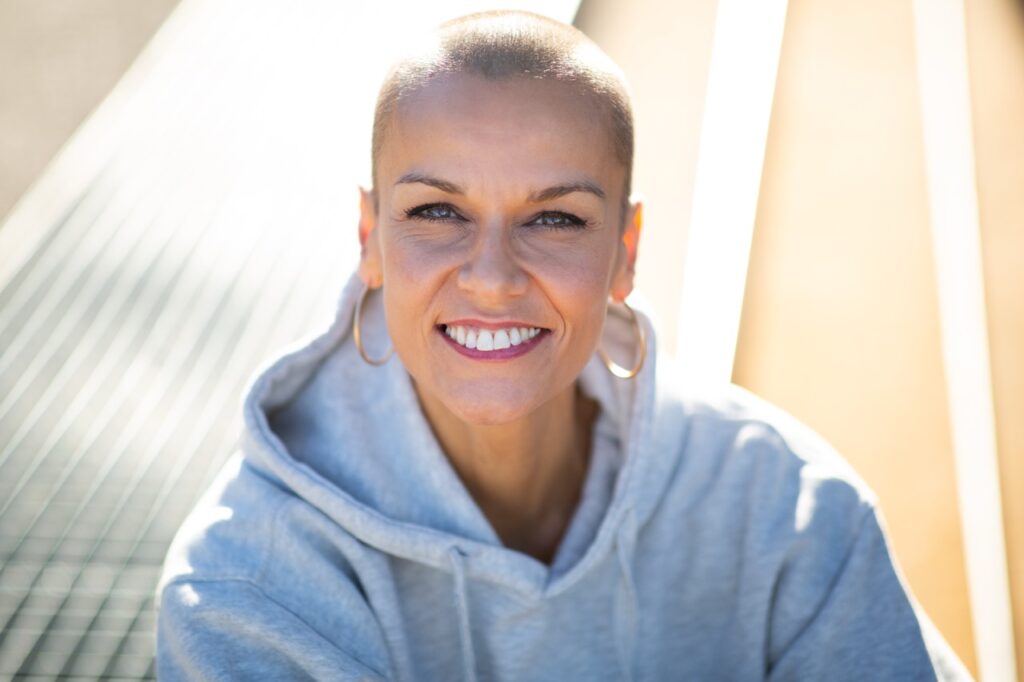 Close up portrait smiling woman with shaved hair